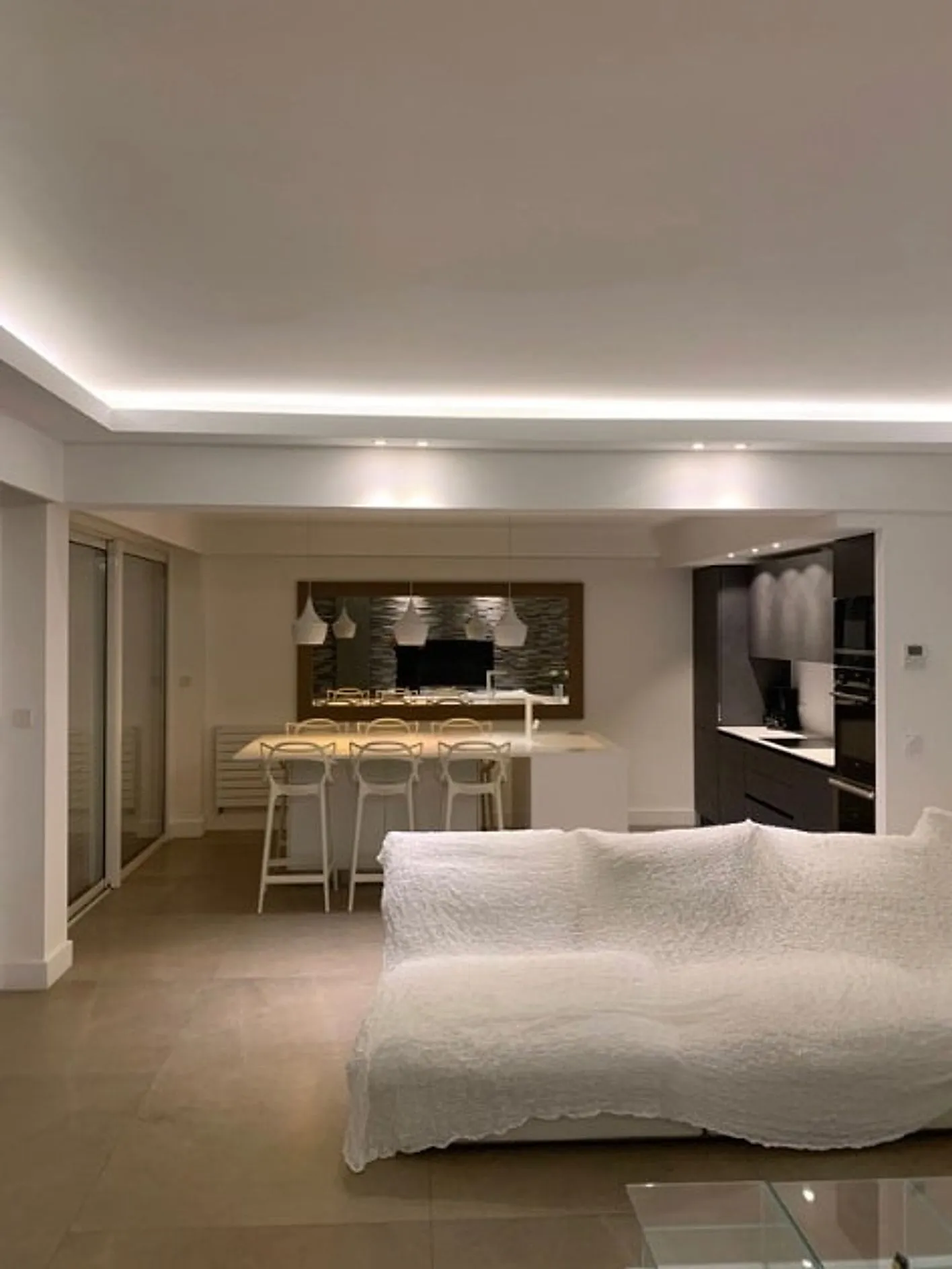 Séjour ouvert sur cuisine, éclairage en corniche et bar, appartement rénové par Expert Habitat à Nice